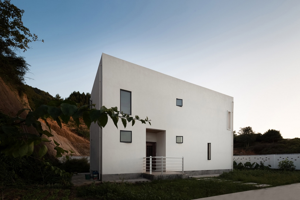 a white hillside house by ming ding spatial art studio
