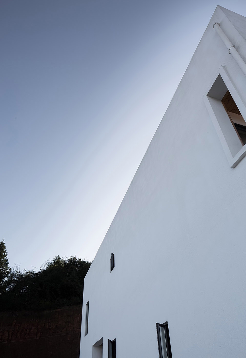 a white hillside house by ming ding spatial art studio